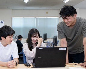 チームメンバーが会議室で笑顔で話し合っている様子